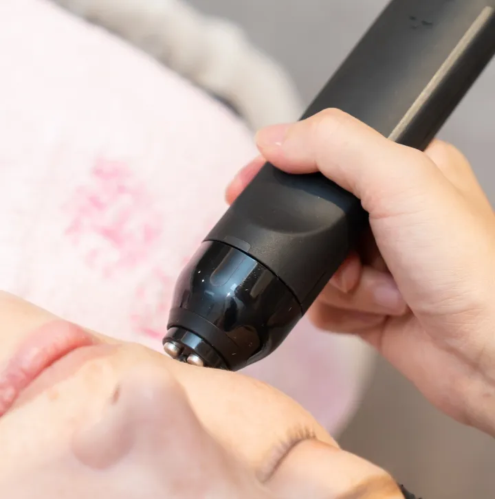 機器で肌のケアをしている